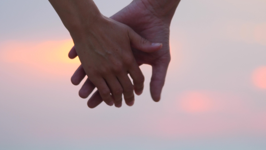 Two lovers with separated hands. A sign of love, close relationships, divorce. Man and woman holding hands, then part against the sky. Couple gesturing concept of ending relationship between them | Shutterstock HD Video #1058446519