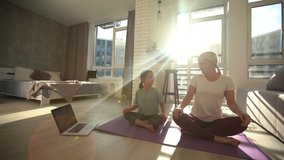 Happy healthy family kid daughter and young mother having fun doing yoga exercises together, smiling mindful mom teaching little cute child girl to meditate laughing at home - Powered by Shutterstock - Get 15% off with code: PIKWIZARD15