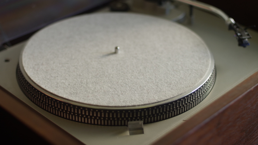 A vinyl record gets placed on a turntable and starts listening to music Royalty-Free Stock Footage #1058447653