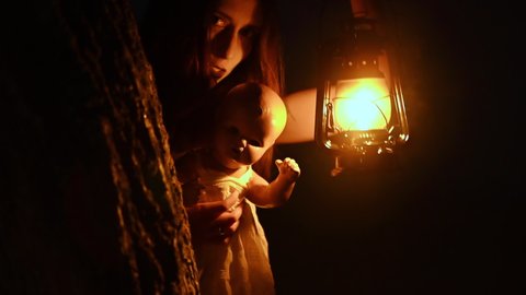 Horror night Scene of a Woman Possessed holding a doll. High quality 4k footage