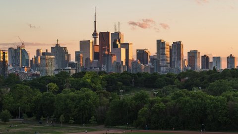Toronto, Ontario, Canada, day to night time lapse view of iconic Toronto skyline and Riverdale Park during summer, zoom out.