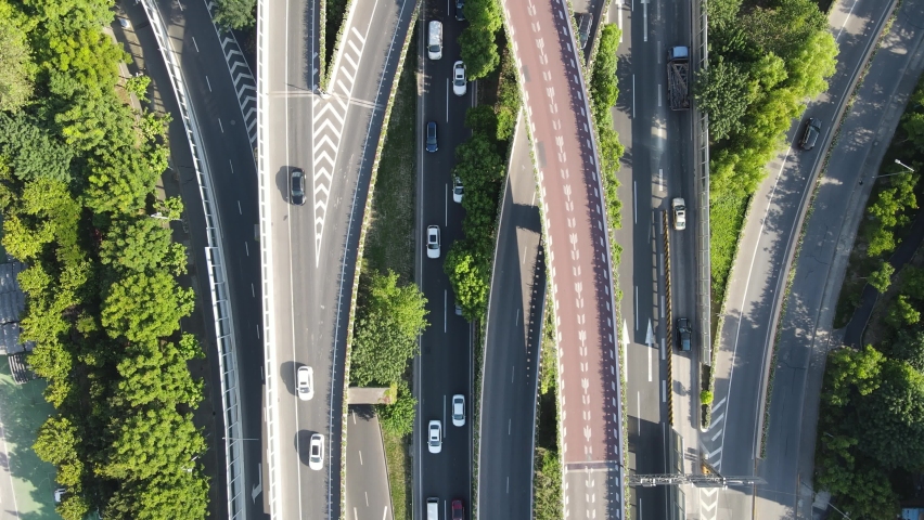 Drone aerial view of curved overpass multi lane highways in daytime summer. Travel tourism and city life transportation concept footage. Trees and green plant around the highway in Shanghai China. Royalty-Free Stock Footage #1058450212