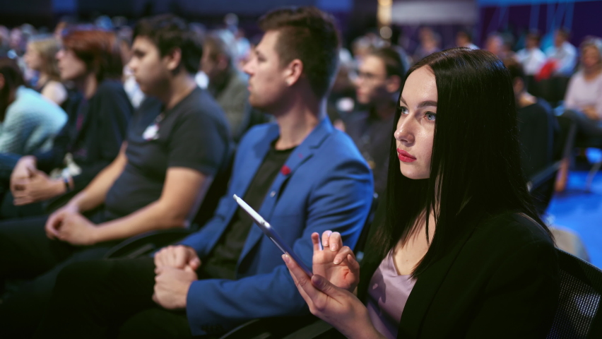 Person type touch screen crowded audience business forum. Viewer conference listen speaker auditorium. Business woman typing hand pad economic summit. Group people learning speech in crowd audience.