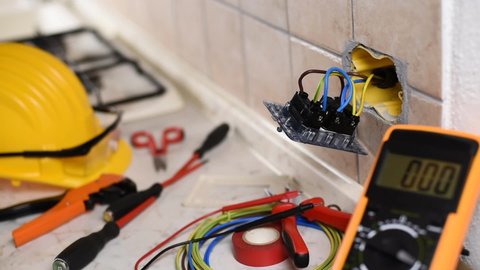 Electrician at work with the tester measures the voltage in the sockets of a residential electrical system. Construction industry. Footage.
