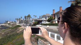 Woman making video of oceanside in California in slow motion 250fps