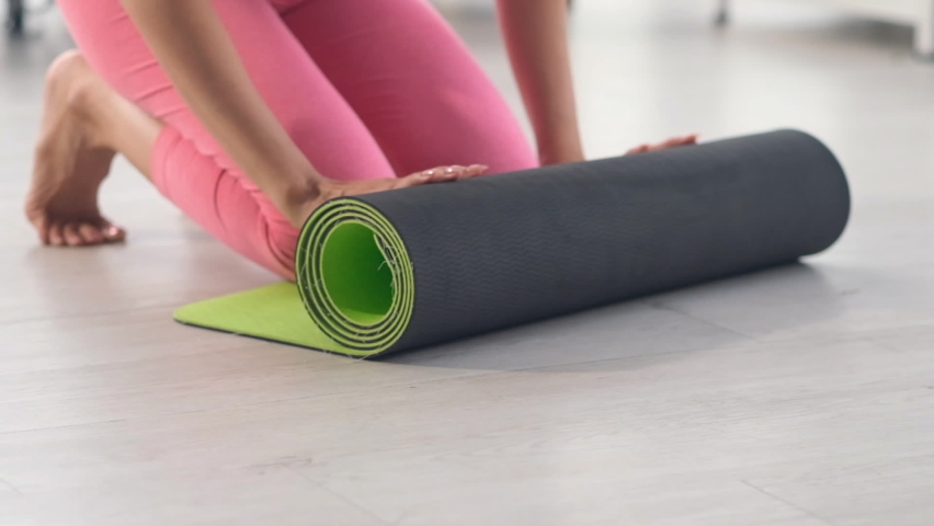 Senior woman using hand unfolds a rug of yoga in yoga class room, yoga time, yoga class. Royalty-Free Stock Footage #1058459695