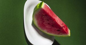 Vertically oriented Stop motion creative concept video animation slice of watermelon bite on green background. Summer dessert