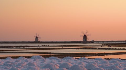 Salt ponds near Trapani in Sicily in Italy at sunset with Mozia island and wind mills. Stock Video