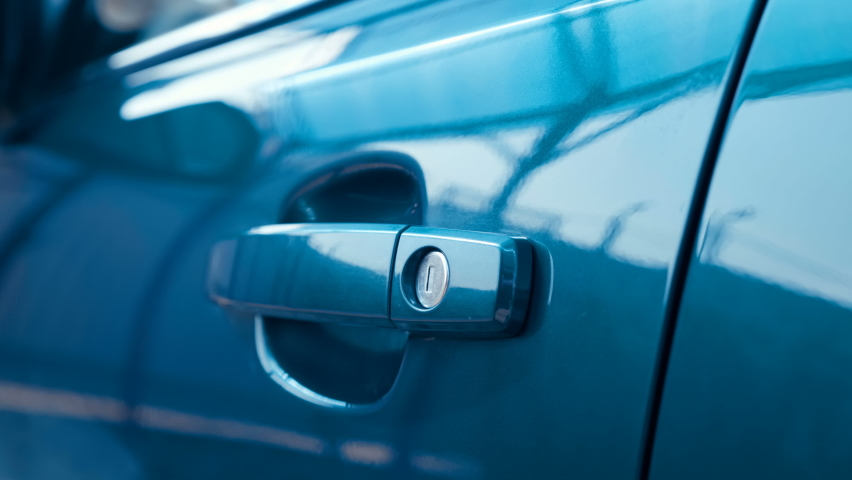 A man, a driver, a buyer opens the driver's seat door, gets behind the steering wheel of a new blue car and closes the door, then gets out of the car and closes the door. Closeup. Shallow depth of fie Royalty-Free Stock Footage #1058473309