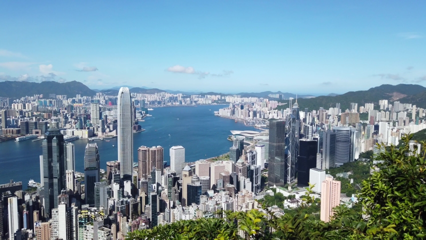 Pan left Aerial view of Hong Kong skyline and bay on a clear day. | Shutterstock HD Video #1058478793