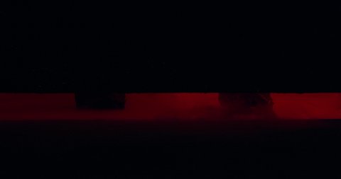 The demon stands behind the door and his hooves hit the floor. Black and red background, in the smoke