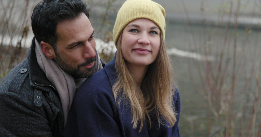 Couple embracing by Isar River and laughing / Munich, Bavaria, Germany