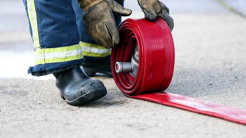 Firefighter rolling fire hose in International Fire Training centre / Darlington, CO Durham, England, UK