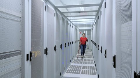 Woman with crutch working in data center / Amsterdam, Noord-Holland, Netherlands