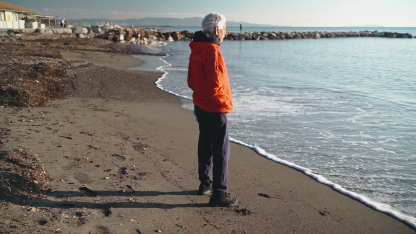 Man standing on beach / Rosignano, Livorno, Italy