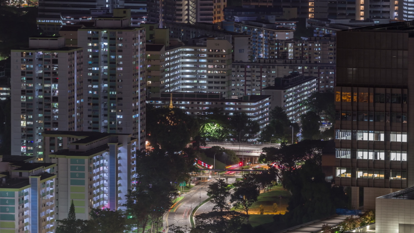 Aerial skyline with apartment buildings and skyscrapers of Singapore night timelapse. Traffic on streets. View from skybridge viewpoint