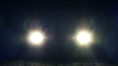 Front view of turning on the headlights in the car at night