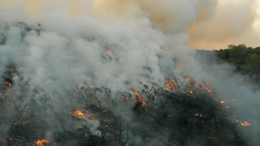 Aerial view at fire at garbage dump, burning pollutes the environment. Ecological catastrophe and destruction of nature, large fire area Royalty-Free Stock Footage #1058496871