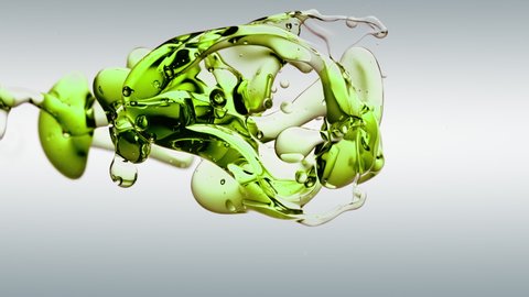 translucent abstract green oil bubbles and fluid shapes isolated in purified water. Side angle with white cosmetic backdrop with copy space for science and advertising.