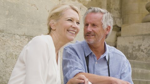 Close Up of Middle Aged Tourist Couple Laughing On Steps