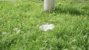 The wind carries plastic wrap across the grass. Environmental pollution