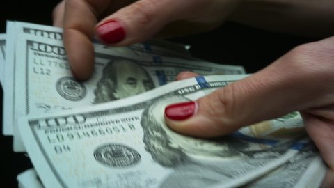 Successful woman checking amount of cash money, money payment concept. Closeup businesswoman hands holding one hundred dollar bills. Unrecognizable lady enjoying dollar banknotes in hands