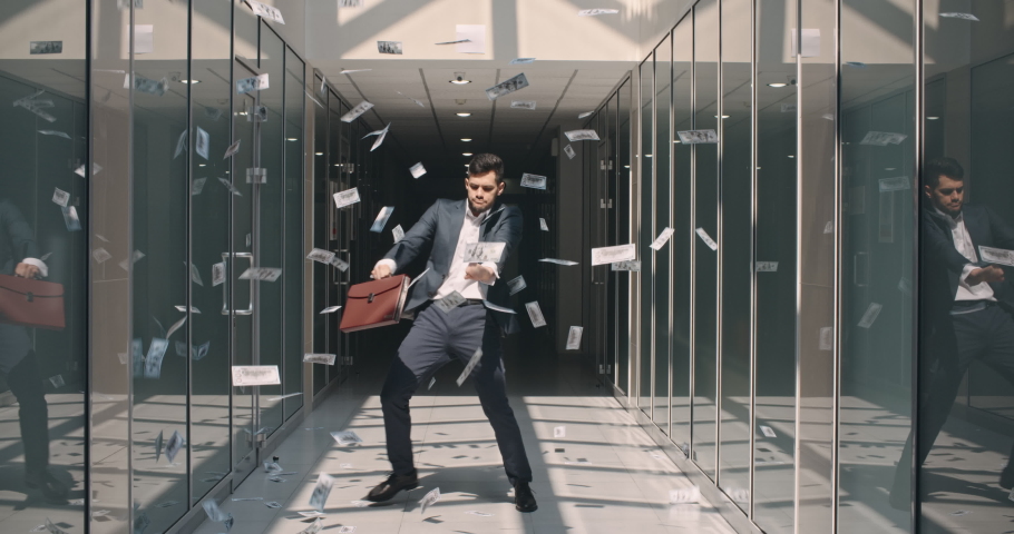 Lucky caucasian businessman is celebrating his victorious achievement by dancing in money rain in office hall - way to success concept 4k | Shutterstock HD Video #1058506615