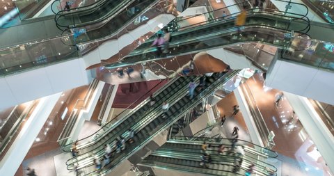 Escalator in modern multi level shopping mall crowd of people. Rush hour. Very busy full of clients mall complex. Consumption concept. Time lapse