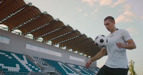 Professional soccer player is juggling a ball. socker a player in a white football uniform at the stadium