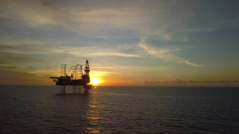 Aerial view from a drone of an offshore jack up rig at the offshore location during sunrise time
