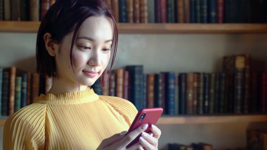 Young asian woman using a smart phone. Communication network concept. IoT (Internet of Things). Telecommunication. Royalty-Free Stock Footage #1058518909