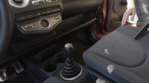 Man cleaning dirty car interior with vacuum cleaner
