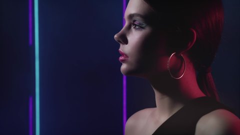 Neon model portrait. Vogue beauty. Girl with night makeup posing in blue purple lights.