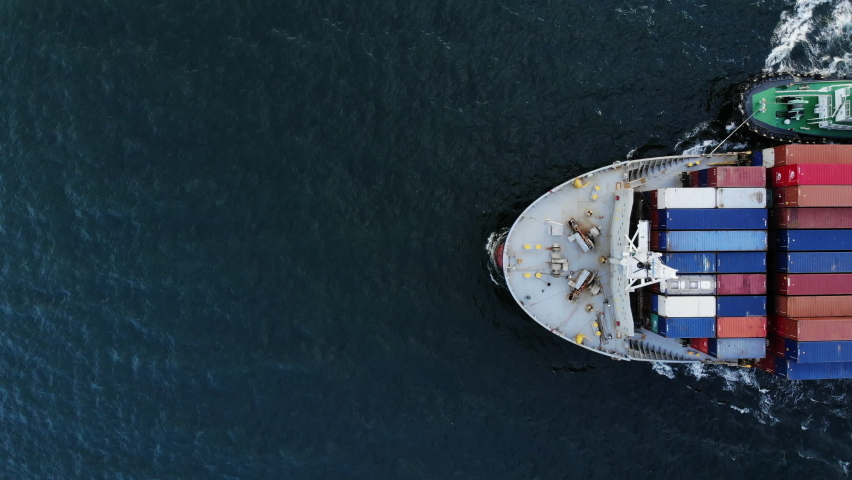Aerial top view of cargo ship carrying container and running with tug boat for export  goods  from  cargo yard port to custom ocean concept freight shipping by ship . Royalty-Free Stock Footage #1058526400