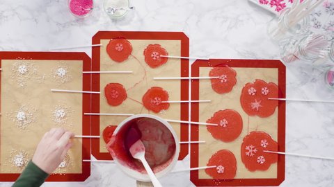 Flat lay. Pouring caramelized sugar on silicone mats to make homemade lollipops.