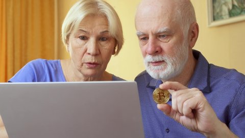 Senior couple work from home. Poor retired family went broke after online investments in cryptocurrency bitcoin and received decrease in savings value. Concept of wealth lost and financial collapse
