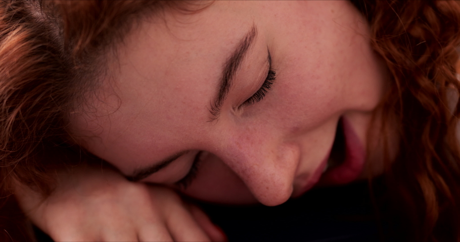 Tired young woman sleeping dozing with head on hands, yawning. Close up of females face asleep.