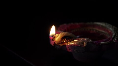 Igniting Decorative Colorful diya lamps during diwali celebration.