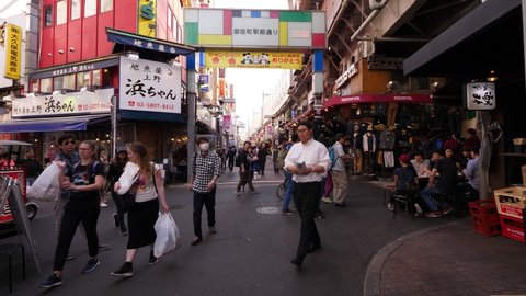 TOKYO - APRIL 04, 2018: Shopping alley at Ueno, people walk around, first person view moving camera. Famous Ameyoko area with many cheap stores and restaurants. Day time shot