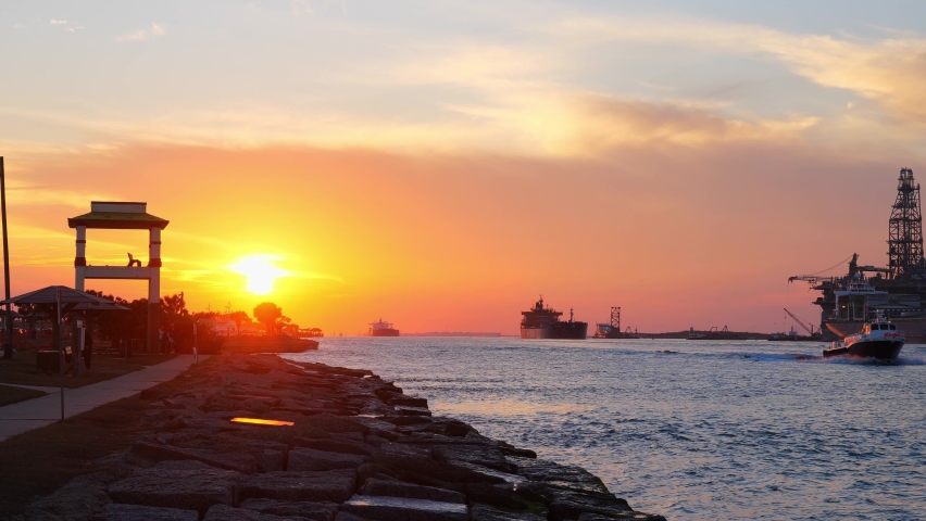Beautiful sunset at Port Aransas, Texas with oil tankers and a boat approaching from Corpus Christi on the water of the ship channel. Royalty-Free Stock Footage #1058544223