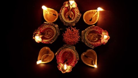 Colorful Diwali oil lamps, Deepavali oil lamps lighted in beautiful formation with flowers in middle. 