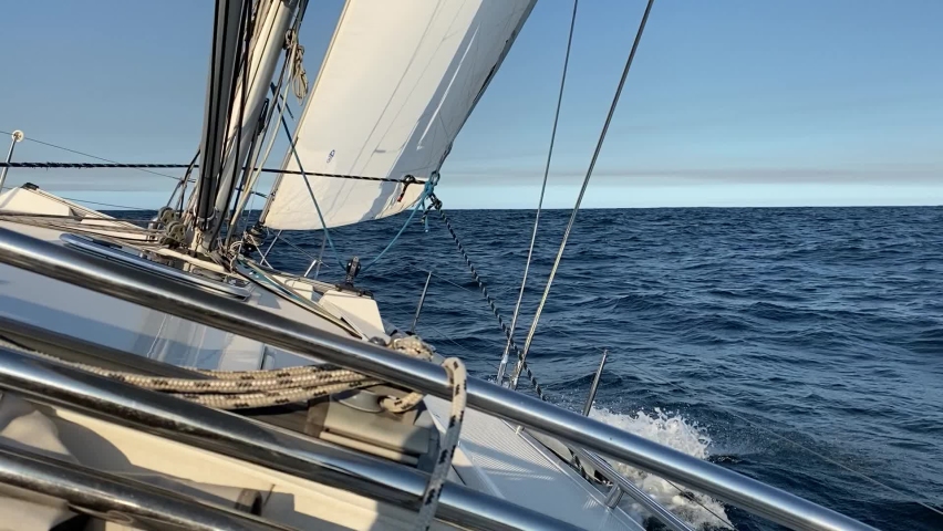 Yacht sailing away from the heads of Sydney Harbor, on a calm and sunny day. View from the boat