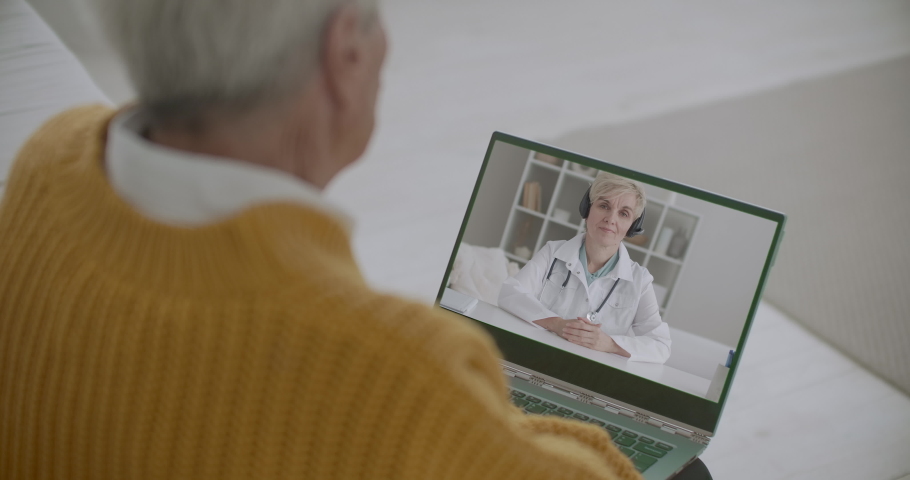 therapist is speaking about new coronavirus infection and preventive measures to old patient by video call, man is listing by laptop Royalty-Free Stock Footage #1058550745