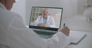 two male doctors are communicating online by web camera of notebook, learning and consulting of health professionals