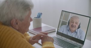 middle-aged man is communicating with his elderly father by online video call on laptop, staying home