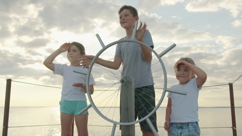 Children at the helm of the ship. Happy childhood.