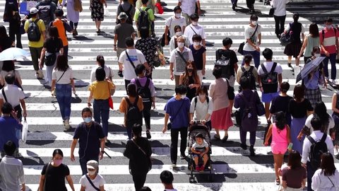 Osaka, Japan - September 5 2020 - People walking crosswalk at Umeda in Osaka,Japan.People wear masks because of the coronavirus.