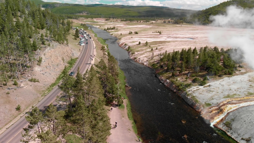 Midway Geyser Basin a smaller basin alongside the Firehole River. The largest hot spring in Yellowstone, Grand Prismatic Spring is also found here