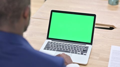 African Man Scrolling Laptop with Chroma Screen