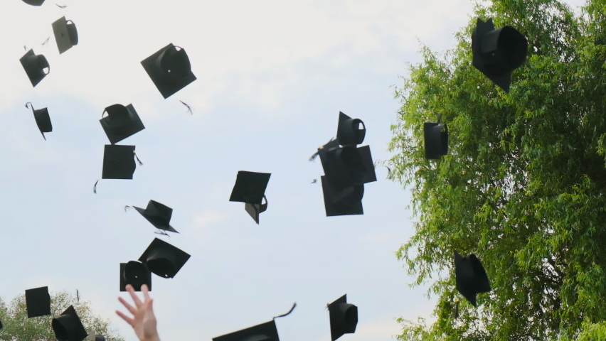 High school students graduate throwing graduation square academic cap bonnet into the sky in slow motion, education college ceremony in front of threes. Hands catching hats after finishing university | Shutterstock HD Video #1058566207